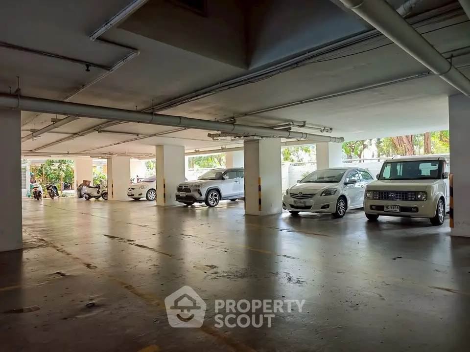 Spacious indoor parking area with multiple cars in a well-lit garage.