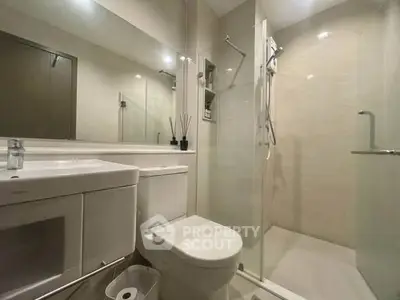 Modern bathroom with glass shower and sleek fixtures in a contemporary apartment.