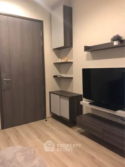 Modern living room with sleek furniture and wall-mounted TV, showcasing contemporary interior design.