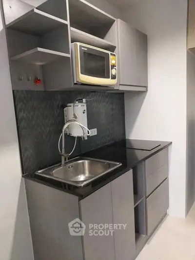 Modern compact kitchen with microwave and sleek cabinetry