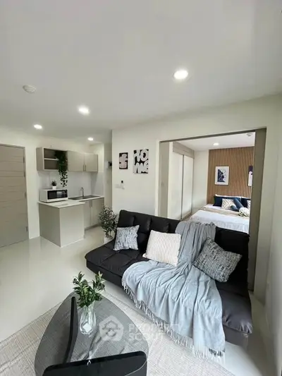 Modern open-plan living room with cozy sofa and stylish kitchen area