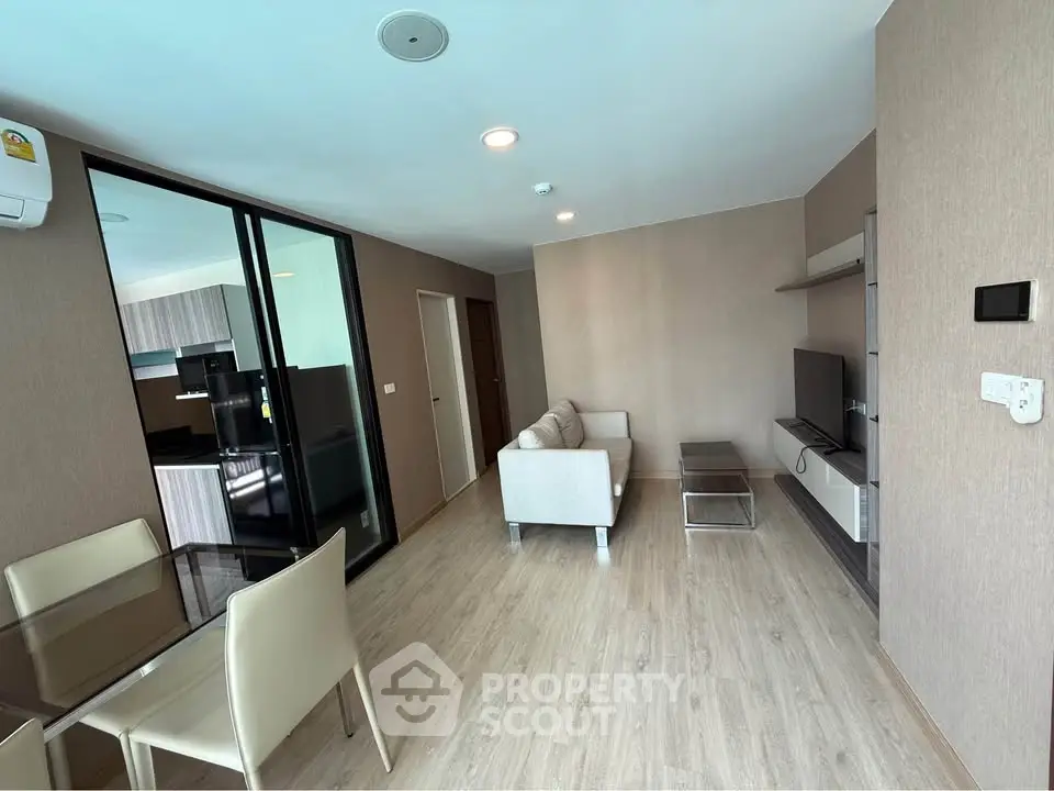 Modern living room with sleek furniture and open kitchen layout in a stylish apartment.
