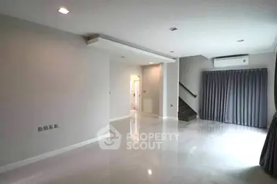 Spacious modern living room with sleek flooring and ample natural light