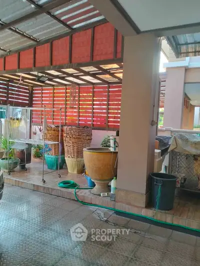 Spacious covered patio with potted plants and laundry area, ideal for outdoor living.