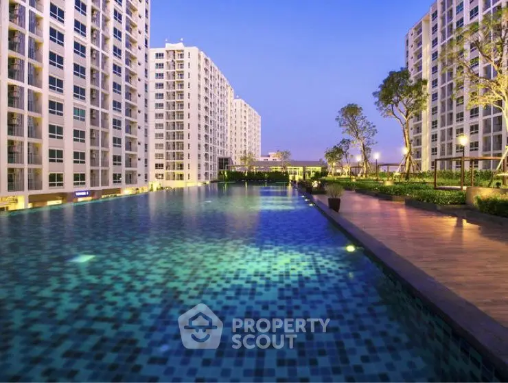 Luxurious apartment complex with stunning pool and landscaped gardens at dusk.