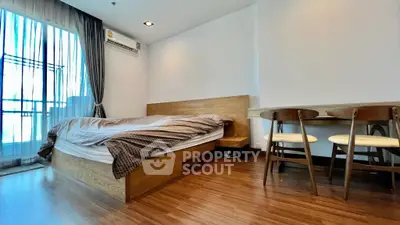 Modern bedroom with wooden flooring and stylish furniture in a bright apartment.