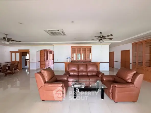 Spacious living room with leather sofas and elegant wooden cabinetry, perfect for entertaining guests.