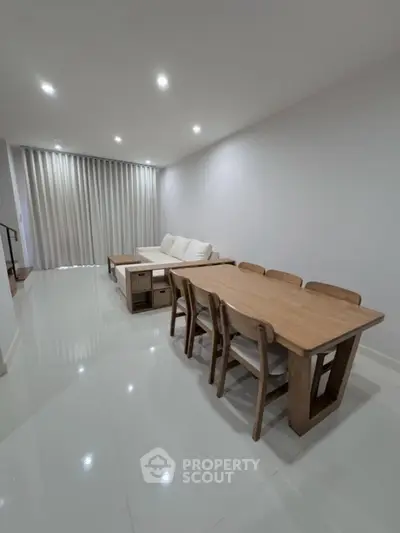 Spacious modern living room with elegant dining area and cozy seating, perfect for family gatherings.