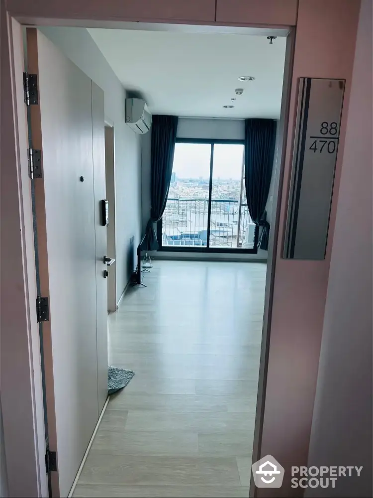 Spacious apartment entrance with large windows and city view