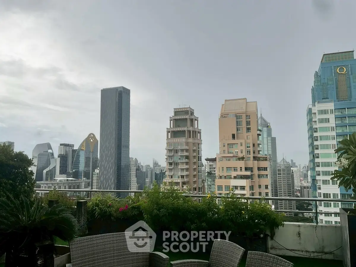 Stunning cityscape view from a lush rooftop terrace with modern seating.