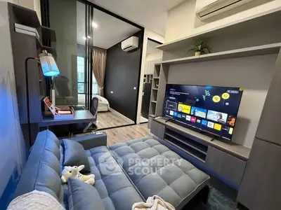 Modern living room with stylish furniture and entertainment setup, featuring a cozy sofa and smart TV.