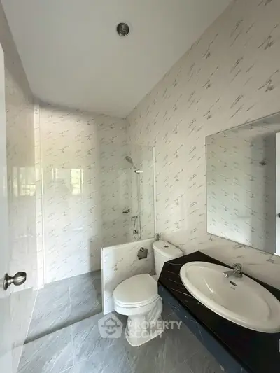 Modern bathroom with sleek design, featuring a glass shower and elegant fixtures.
