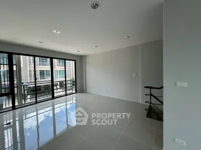 Spacious modern living room with large windows and sleek tile flooring