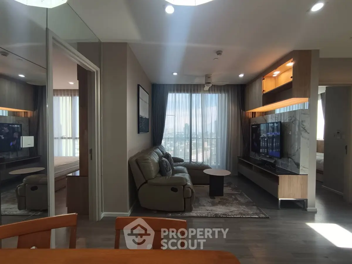 Modern living room with sleek furniture and large windows offering a stunning city view.