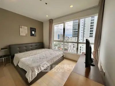 Modern bedroom with city view, featuring a large bed and sleek furniture in a high-rise apartment.