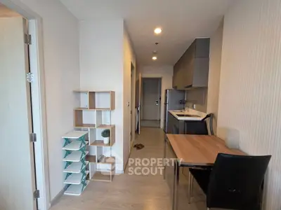 Modern apartment interior with sleek kitchen and dining area, featuring stylish shelving and contemporary design.