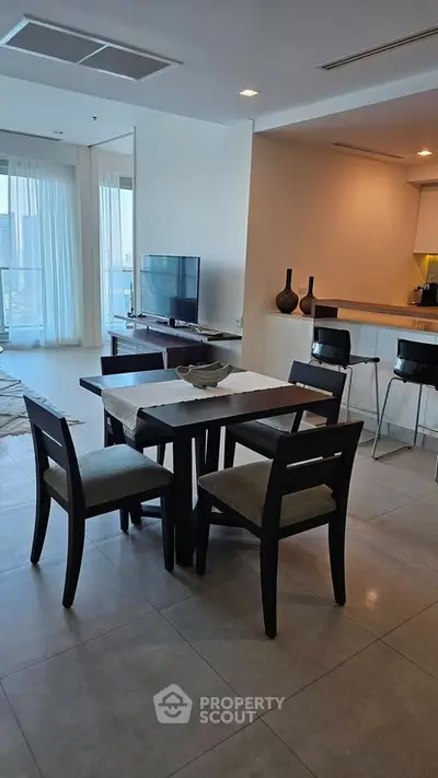 Modern dining area with elegant furniture and open kitchen layout in a stylish apartment.