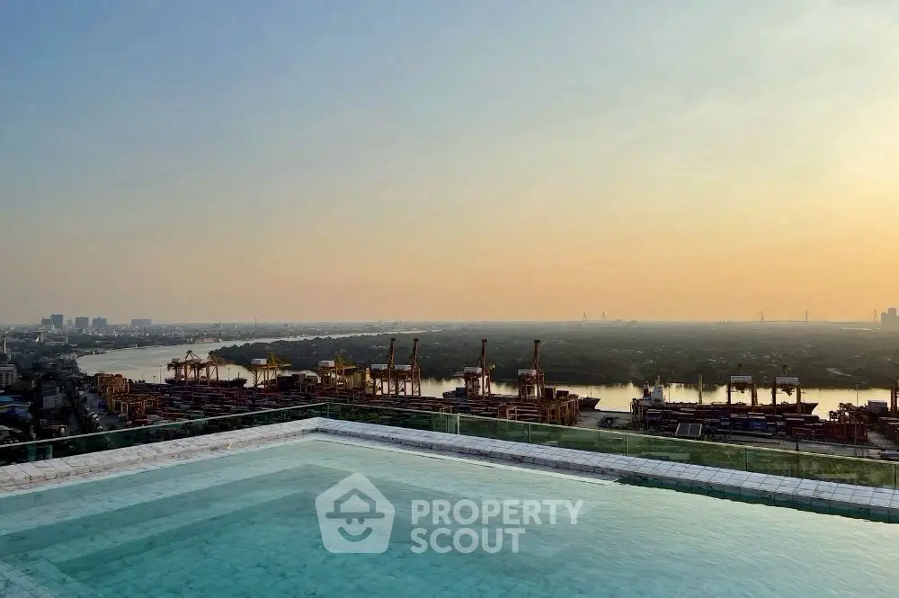 Stunning rooftop pool with panoramic city and river views at sunset.