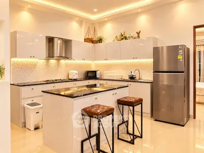 Modern kitchen with sleek cabinets, island seating, and stainless steel appliances
