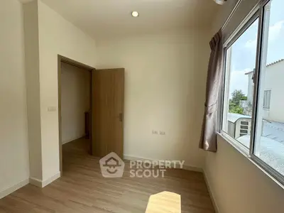 Bright and airy bedroom with large window and wooden flooring, perfect for natural light lovers.