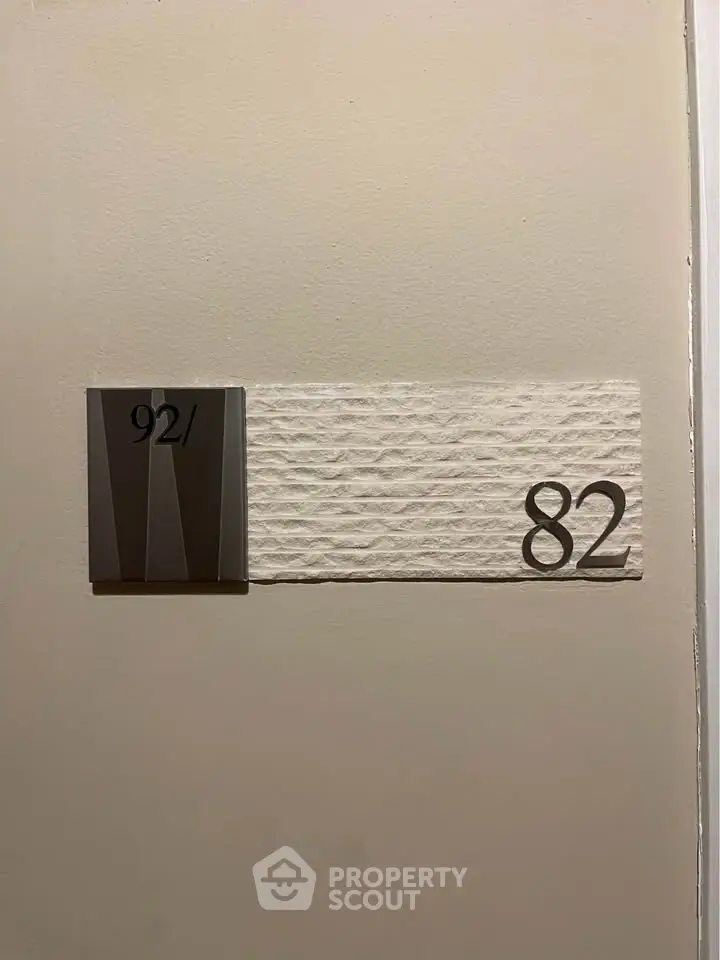 Modern apartment door with stylish number plaque, showcasing sleek design and contemporary elegance.