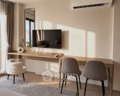 Modern study area with sleek desk, wall-mounted TV, and stylish chairs in a bright apartment.