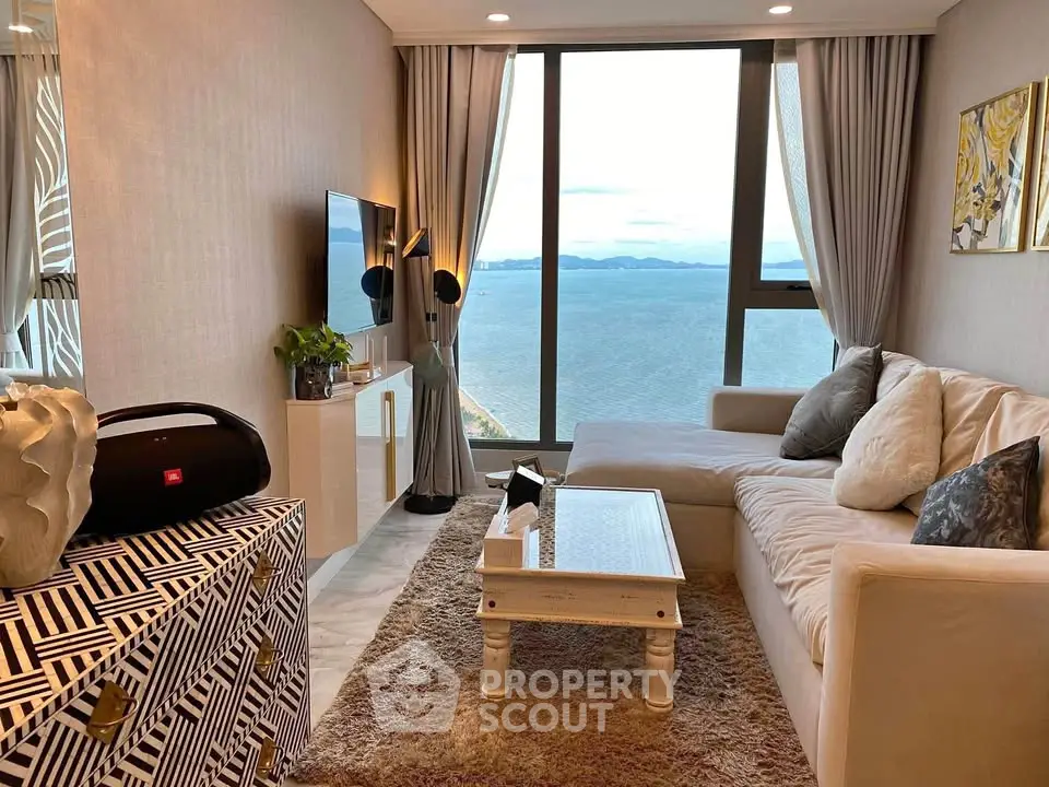 Luxurious living room with stunning ocean view, elegant decor, and cozy seating area in high-rise apartment.
