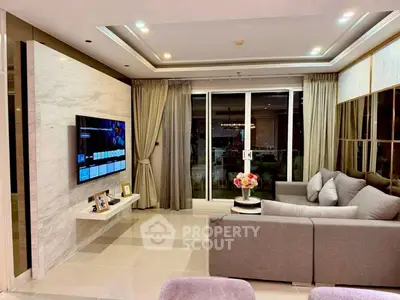 Modern living room with sleek design, large TV, and cozy gray sofa, perfect for relaxation and entertainment.