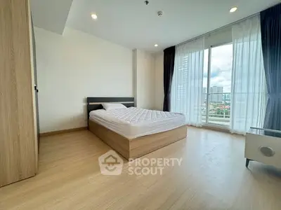 Spacious bedroom with large window offering stunning city views, modern wooden flooring and elegant decor.