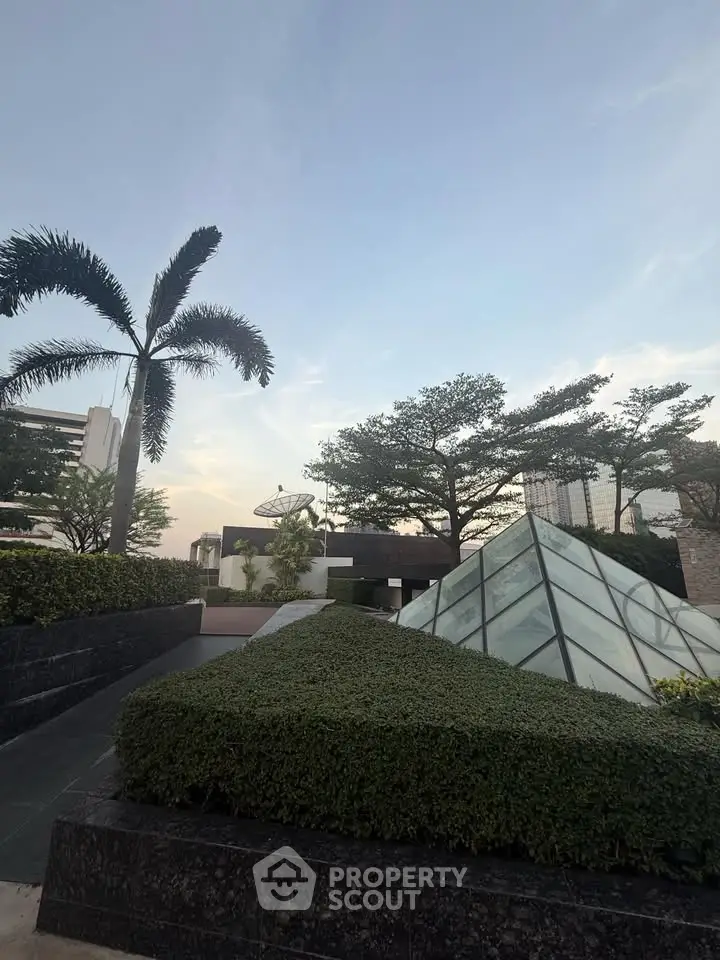 Stunning rooftop garden with lush greenery and modern glass structures, offering a serene urban oasis.