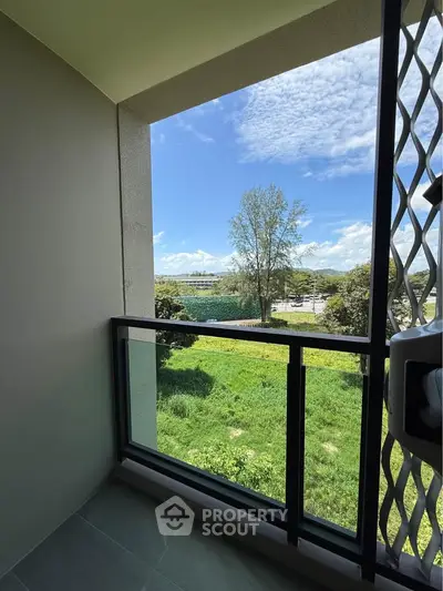 Charming balcony with lush green view and clear blue sky, perfect for relaxation.