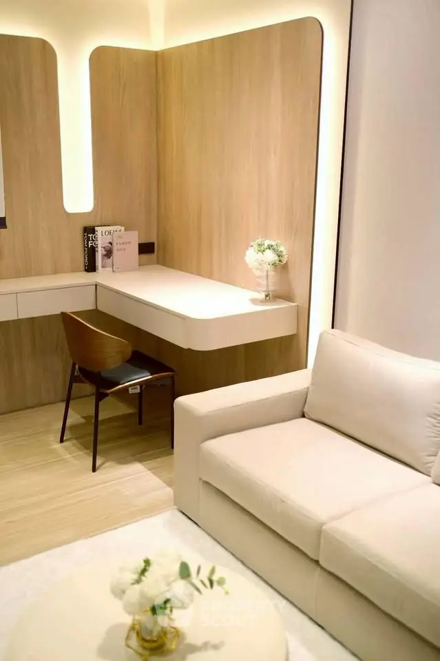 Modern living room with stylish furniture and elegant decor, featuring a cozy sofa and a sleek study area.