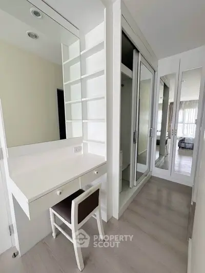 Modern bedroom with built-in wardrobe and vanity in a bright, minimalist design.