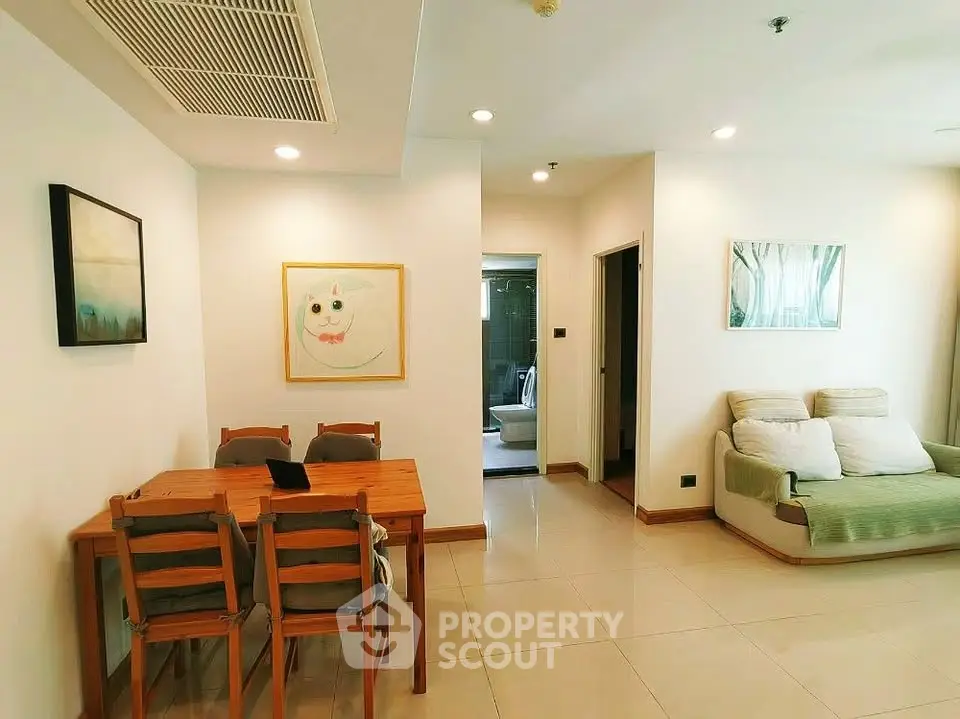 Spacious living room with dining area and modern decor in a bright apartment.