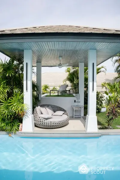 Luxurious poolside cabana with stylish seating and lush greenery