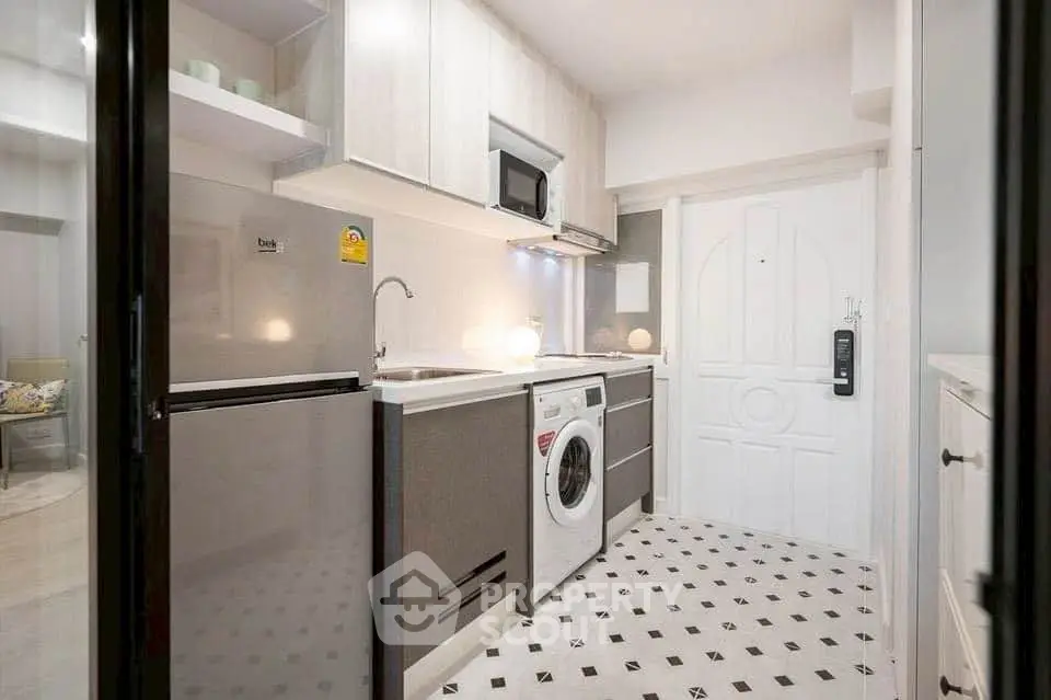 Modern kitchen with sleek appliances and stylish flooring in a compact layout.