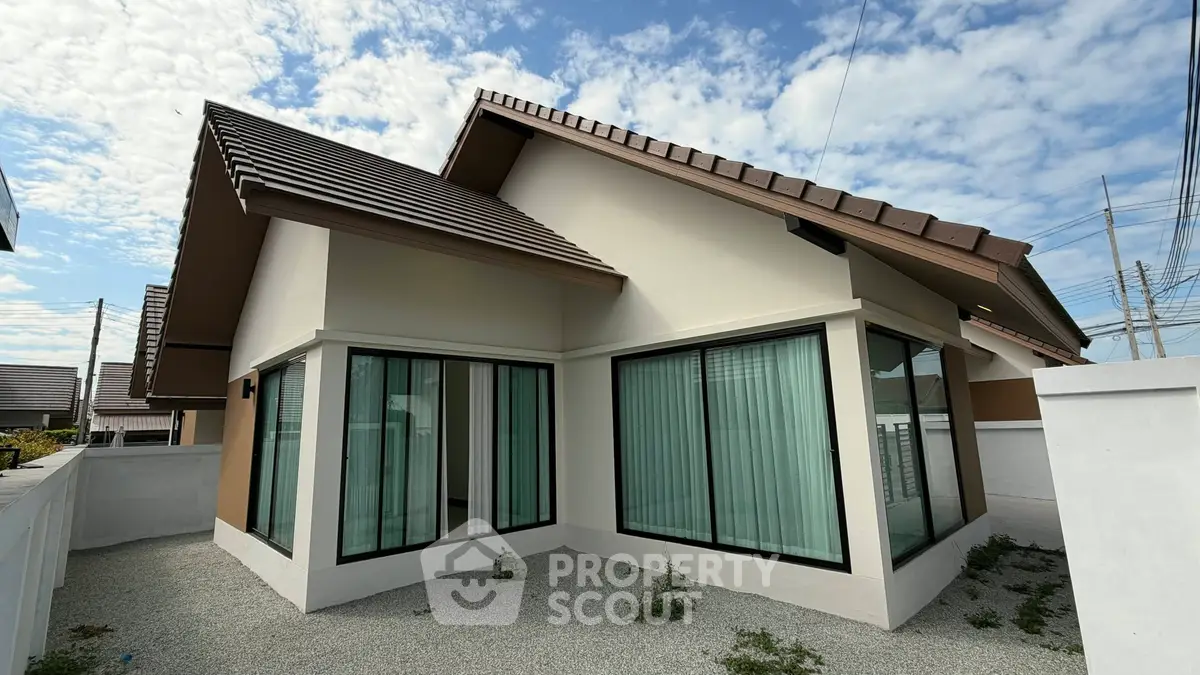 Modern single-story house with large windows and sloped roof, perfect for family living.