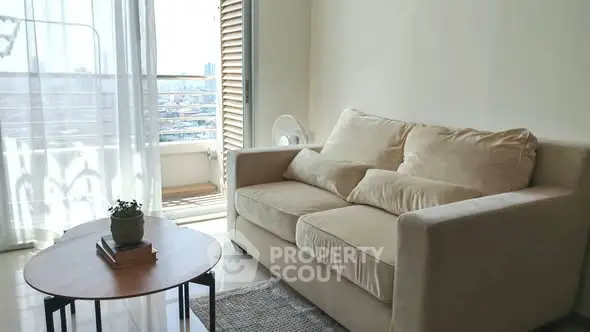 Bright living room with cozy sofa and balcony view