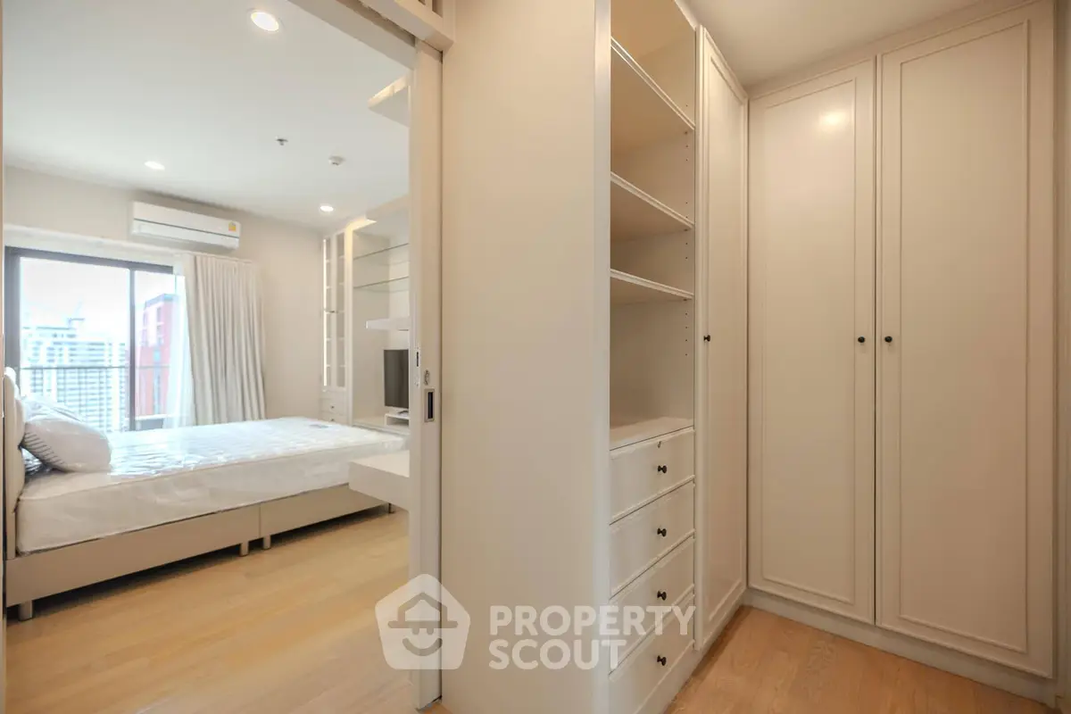 Spacious bedroom with walk-in closet and modern design in a luxury apartment.