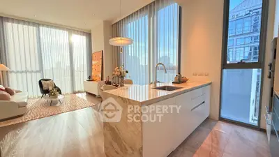 Luxurious open-plan living room and kitchen with floor-to-ceiling windows and modern decor.