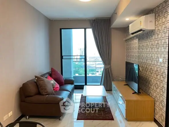 Modern living room with balcony view, stylish decor, and comfortable seating in a high-rise apartment.