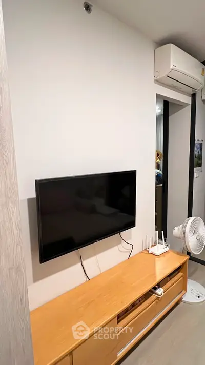 Modern living room with wall-mounted TV and air conditioning unit