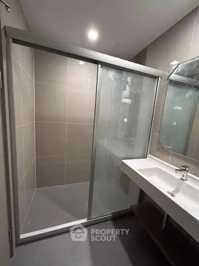 Modern bathroom with sleek shower and stylish sink in contemporary design.