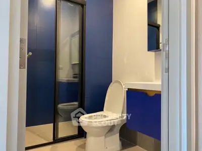 Modern bathroom with blue accents and glass shower enclosure