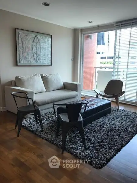 Modern living room with stylish furniture and large windows offering city views.