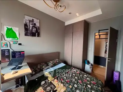 Cozy bedroom with modern decor and workspace, featuring a comfortable bed and ample storage.