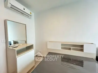 Modern bedroom with sleek furniture and air conditioning, perfect for comfortable living.