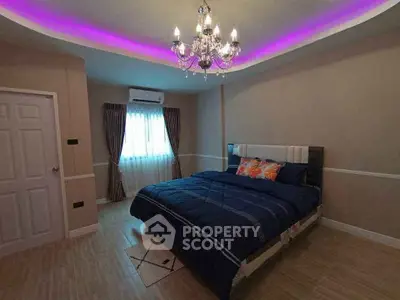 Elegant bedroom with chandelier and ambient lighting, featuring a cozy bed and stylish decor.
