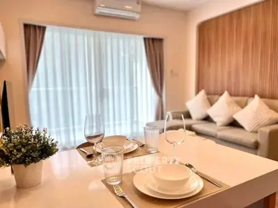 Modern living room with elegant dining setup and cozy sofa, featuring stylish decor and natural light.