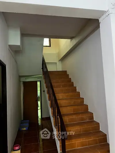 Spacious interior staircase with wooden steps and sleek railing in modern building
